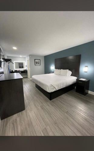 1 dormitorio con 1 cama grande y paredes azules en Rodeway Inn San Antonio Downtown en San Antonio