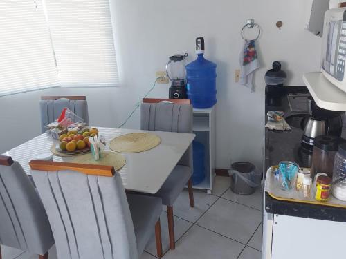 a kitchen with a table with a bowl of fruit on it at Apartamento frente mar - Barra da Tijuca in Rio de Janeiro