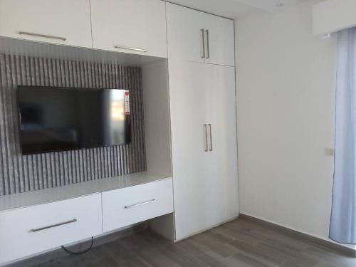 a living room with white cabinets and a flat screen tv at Apt con vista al Mar 1Br-1Bath in La Romana