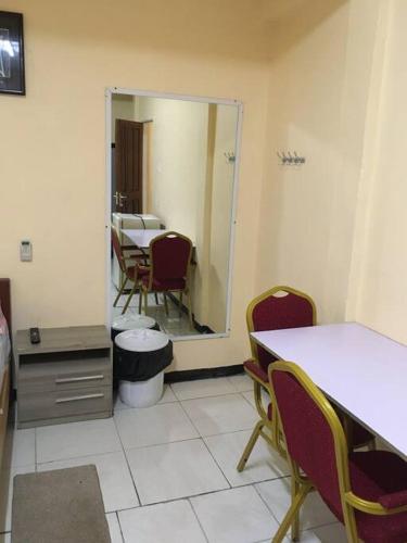 um quarto com um espelho e uma mesa e cadeiras em Hotel Mangueira em Paramaribo