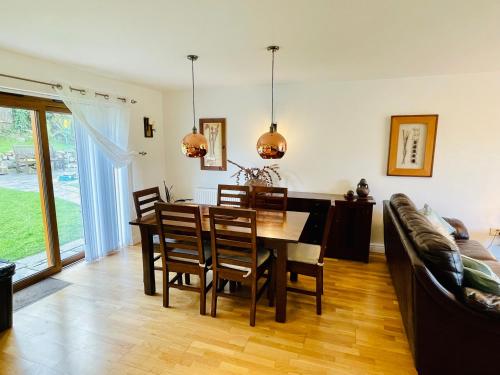 a dining room with a table and a couch at Yr Encil in Gaerwen