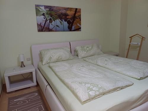 - un lit avec des draps et des oreillers blancs dans l'établissement Ferienwohnung Lastro, à Cochem