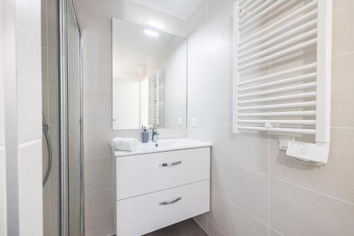 a white bathroom with a sink and a shower at Queen Riviera : climatisation, parking, terrasse in Menton