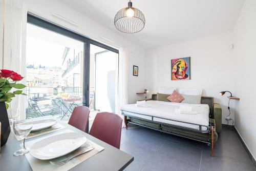 a bedroom with a bed and a table with a dining room at Queen Riviera : climatisation, parking, terrasse in Menton