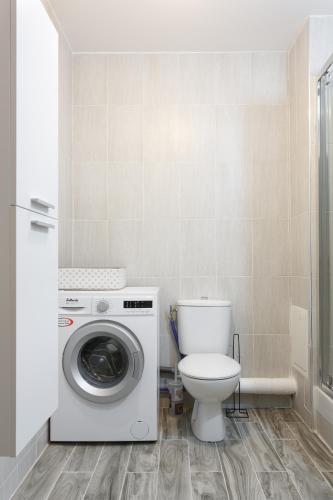 une salle de bain avec machine à laver et toilettes dans l'établissement Appartement confortable Proche de Paris - Balcon - Parking & Wifi, à Argenteuil