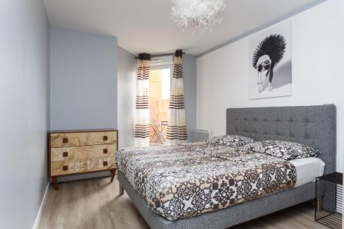 une chambre avec un lit et un lustre dans l'établissement Appartement confortable Proche de Paris - Balcon - Parking & Wifi, à Argenteuil