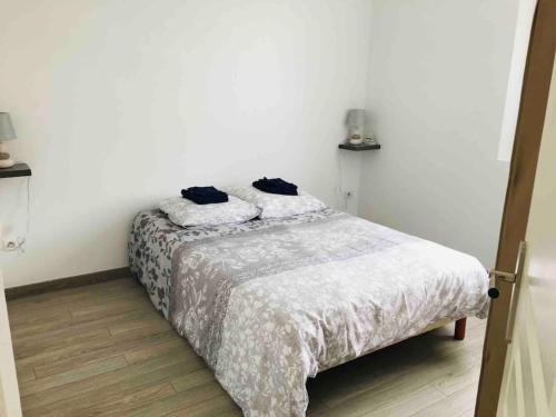 une chambre avec un lit avec deux oreillers dessus dans l'établissement Maison « Au petit Bonheur » chatelaillon plage, à Châtelaillon-Plage