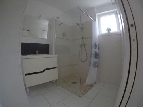 une salle de bain blanche avec une douche et un lavabo dans l'établissement Maison « Au petit Bonheur » chatelaillon plage, à Châtelaillon-Plage