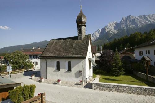 a small white church with a steeple in a village at Ferienwohnung Bergspitz in Grainau