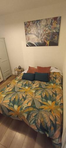 une chambre avec un lit avec une couette colorée dans l'établissement Maison à 20 min de Paris et liaison CDG (transports à 5 min à pied), à Saint-Brice-sous-Forêt
