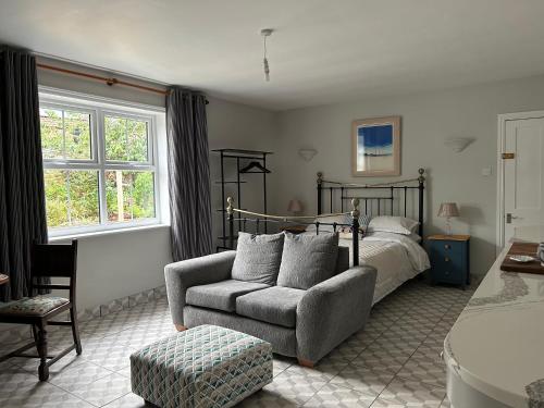 a bedroom with a bed and a couch and a chair at Caistor Bed & Breakfast in Caistor