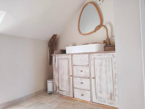 uma casa de banho com um lavatório e um espelho numa cómoda em Maison Béganne - Nature & Charme em Béganne