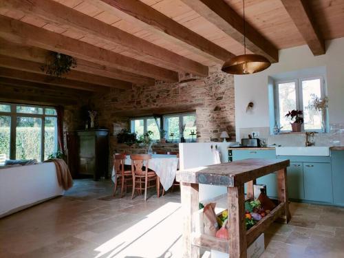 uma cozinha com armários azuis e uma mesa num quarto em Maison Béganne - Nature & Charme em Béganne