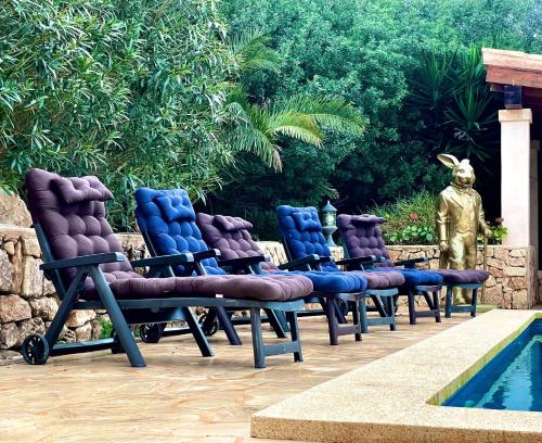 a row of chairs sitting next to a swimming pool at Casa Baleares TS SL in Cala Santanyi