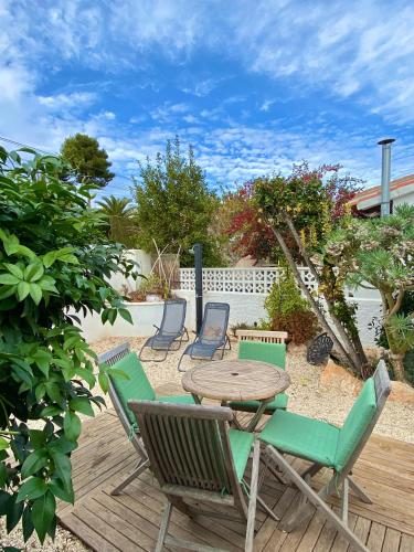 a patio with a wooden table and chairs at Bungalow Steps from Moraira in Teulada