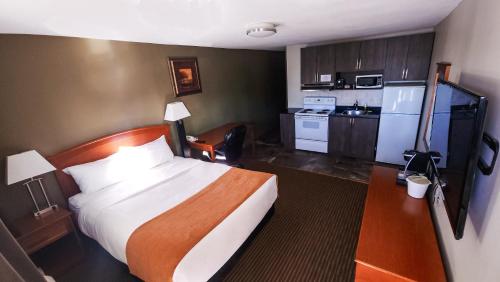 a hotel room with a bed and a kitchen at Horizon Inn & Steakhouse in Valleyview
