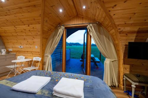 a bedroom with a bed in a wooden house at Missin' Link Glamping in West Hoathley