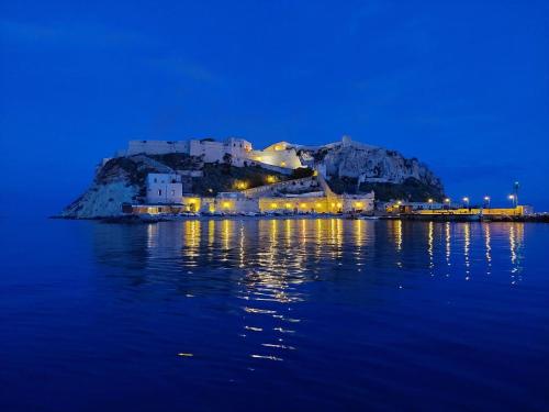 una città seduta in cima a una collina in acqua di notte di Relais Al Faro Bed&Breakfast a San Domino