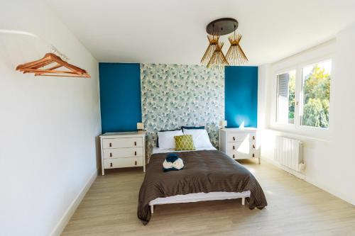 1 dormitorio con paredes azules y 1 cama. en A1, en Évaux-les-Bains