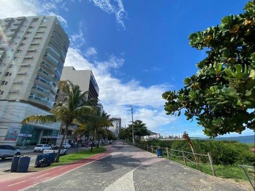 una calle en una ciudad con palmeras y un edificio en Flat na praia da Costa!, en Vila Velha