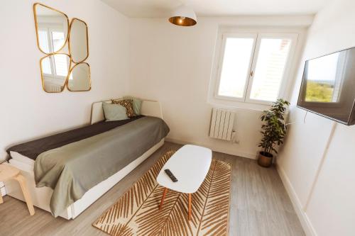 Dormitorio pequeño con cama y mesa en A1, en Évaux-les-Bains