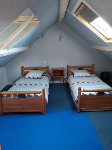Cette chambre mansardée comprend 2 lits. dans l'établissement L'Abri Côtier, à Yport