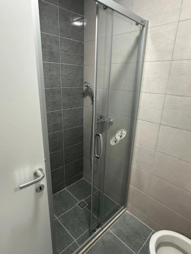 La salle de bains est pourvue d'une douche avec une porte en verre. dans l'établissement Lux Apartment 31, à Lukavica