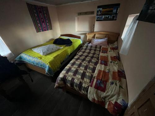 Duas camas sentadas uma ao lado da outra num quarto em MOON NIGHT Amantani Lodge em Ocosuyo