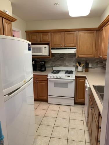 a kitchen with white appliances and wooden cabinets at Bill’s On Little Pigeon River in Pigeon Forge