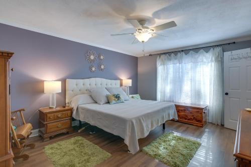 una camera con letto bianco e ventilatore a soffitto di Lakefront Radford Home with Wraparound Deck! a Radford