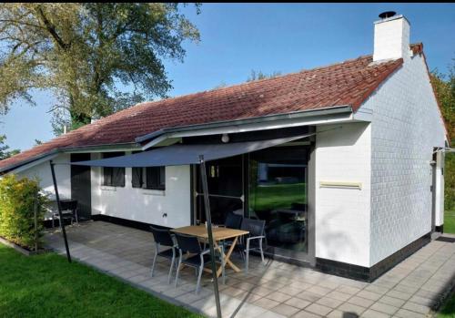 a small white building with a table and chairs at Casa Merle in Westouter