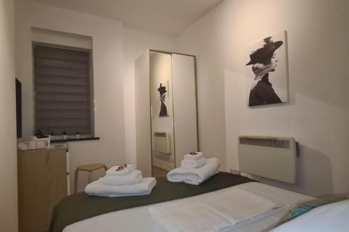 a bedroom with a bed with two towels on it at Top Hat Luton flat free parking in Luton