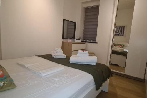 a bedroom with a bed with two towels on it at Top Hat Luton flat free parking in Luton