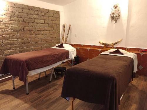 a room with two beds and a brick wall at Finca Marix, Villa del Carbón in Villa del Carbón