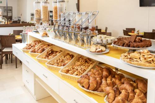 um buffet de pães e produtos de pastelaria em exposição em Hotel Minerva em Siena