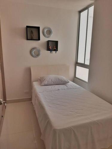 a bedroom with a bed and two pictures on the wall at Precioso Apartamento en Condominio- Ricaurte in Ricaurte