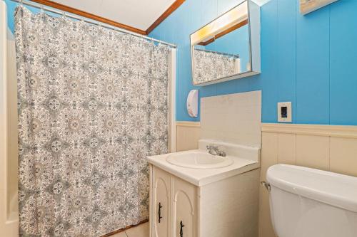 a bathroom with a sink and a toilet and a shower at Oceanside Court by KEES Vacations in Nags Head