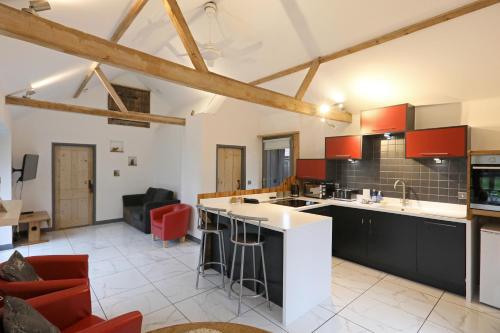 a kitchen with red cabinets and a white counter top at The Old Corn Store Rural Escape Farmstay Barn in Norwich