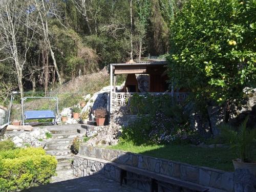 a garden with a stone wall and a house at Casa Molily in Llanes