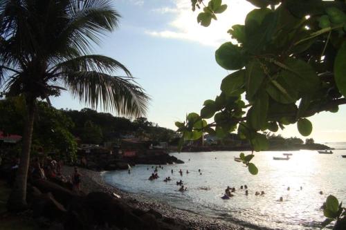 a group of people in the water at a beach at Le Colibri, belle vue mer, accés direct à la plage, SPA privatif in Bouillante