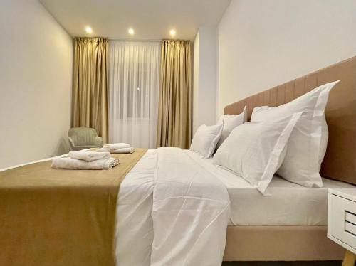 YamaLuxe Apartments - Silent & Primitive With Relaxing Area في بوخارست: غرفة نوم بسرير ابيض كبير مع مخدات بيضاء