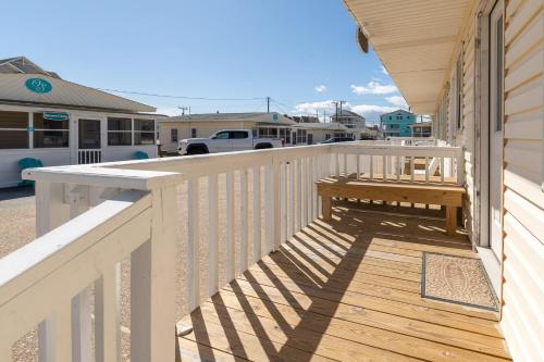 een houten terras met een bank aan de zijkant van een huis bij Oceanside Court by KEES Vacations in Nags Head