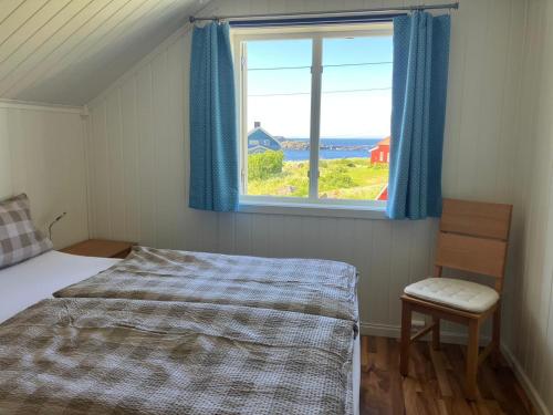 1 dormitorio con cama y ventana en Koselig Hytte mellom sjø og fjell, en Nykvåg