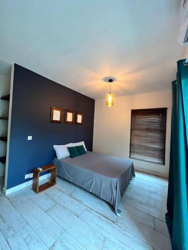 a bedroom with a bed with a blue wall at Cosy suite in the heart of Ebene in Quatre Bornes