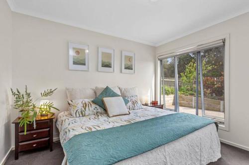 Un dormitorio con una cama grande y una ventana en Tuxion House, en Apollo Bay