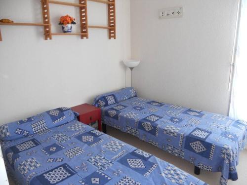 - 2 lits jumeaux dans une chambre avec des draps bleus dans l'établissement Appartement avec belle vue mer - S04117, à Soulac-sur-Mer