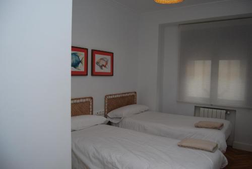 2 camas en una habitación con paredes blancas en Nuevo piso en el centro de Córdoba, en Córdoba