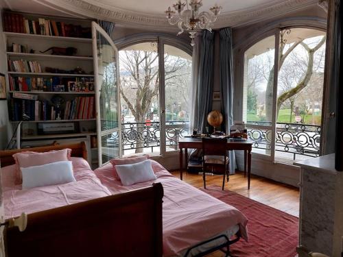 une chambre avec un lit, un bureau et des fenêtres dans l'établissement Bel appartement Paris centre, à Paris