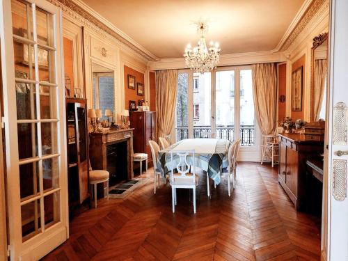 une salle à manger avec une table et un lustre dans l'établissement Bel appartement Paris centre, à Paris