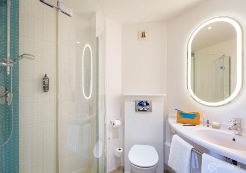 a bathroom with a toilet and a sink and a shower at ibis Lyon Sud Vienne Saint-Louis in Vienne
